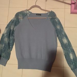 This is a size medium blue/green sweater with lace sleeves